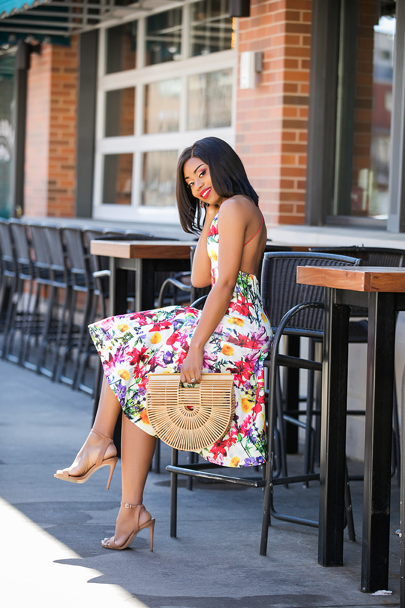 modelka w sukience z hortensjami stoi na moście nad strumieniem w lesie