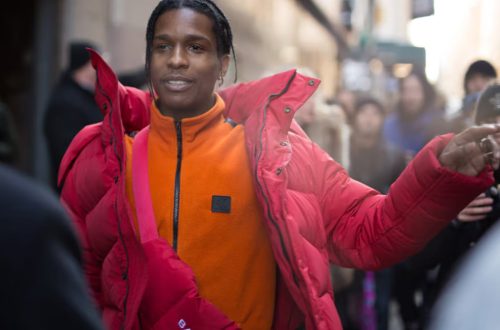 mężczyzna w wodoodpornej kurtce Gore-Tex trekkingowych spodniach butach i plecaku na miejskiej ulicy