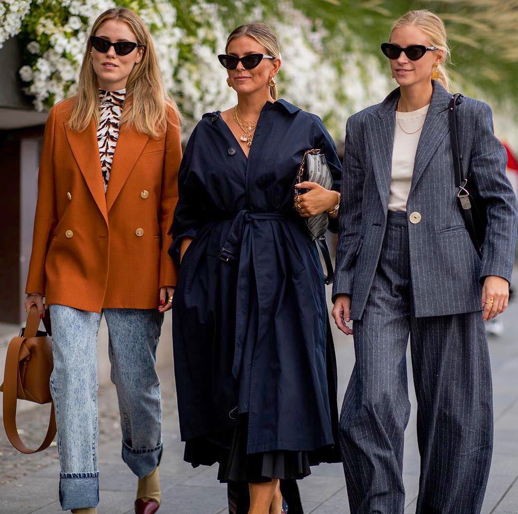 dwie kobiety w białych sneakersach i oversize kurtkach idą po zaśnieżonej ścieżce